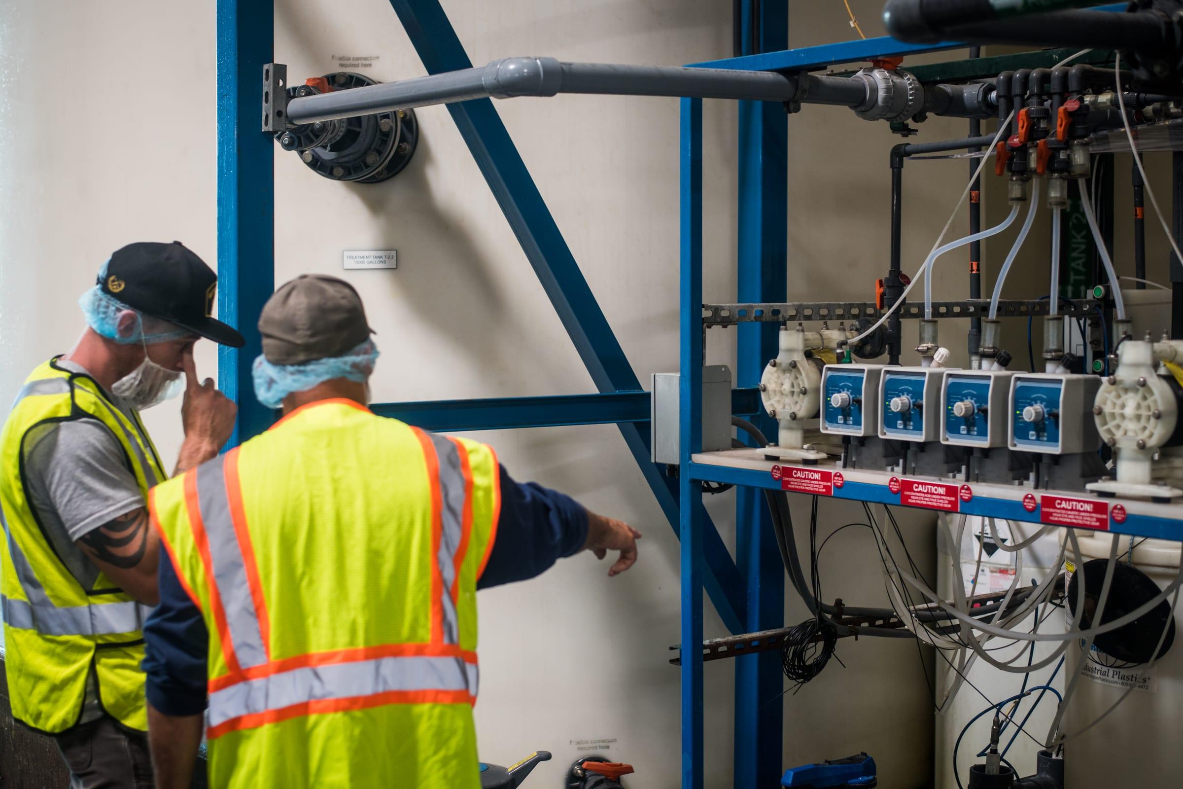Technicians at a chemical injection pump skid