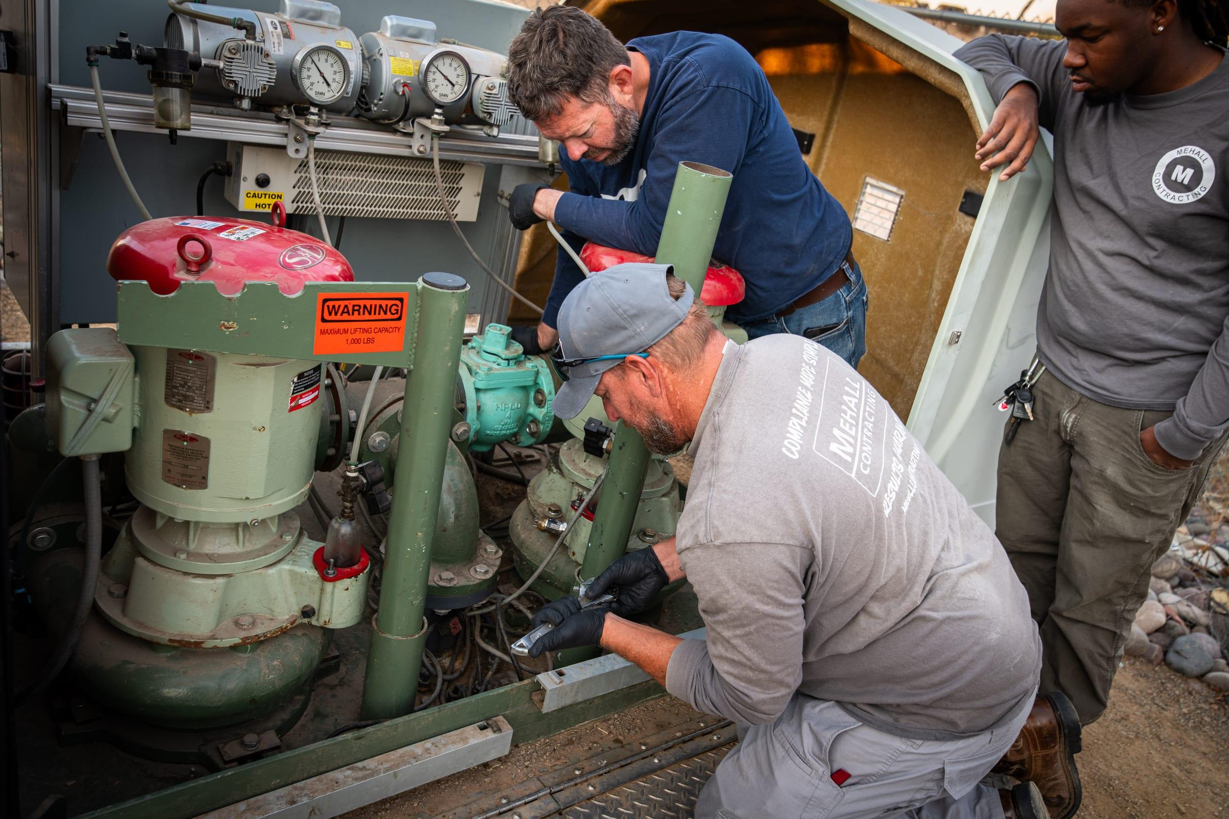 Technicians repairing a lift station pump assembly