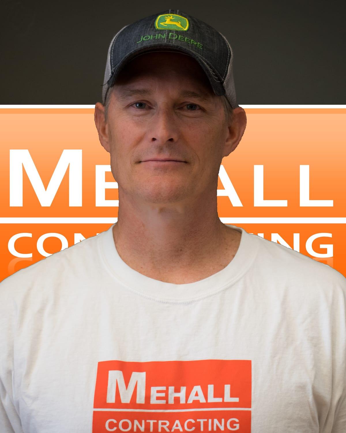 Todd Mehall in front of the Mehall Contracting logo